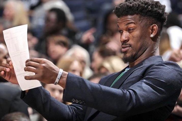 Jimmy Butler reading a piece of paper with a knowing look